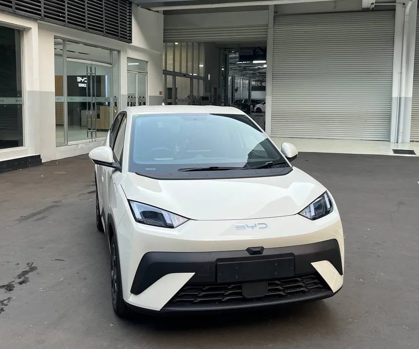 BYD ATTO 1 tampak depan-samping, warna putih, di sebuah pusat layanan BYD